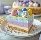 A slice of cake with a white whipped cream topping and colorful sprinkles.