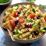 A bowl of pasta salad with vegetables.