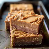 A piece of chocolate cake with nuts on top.