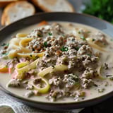 A bowl of pasta with meat and vegetables.