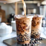 A cup of bubble tea with black tapioca pearls.