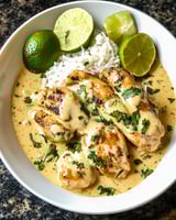 A plate of chicken with rice and lime.