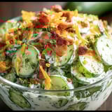 A bowl packed with Cucumber Ranch Crack Salad, loaded with cucumbers, crispy bacon, and cheddar cheese.
