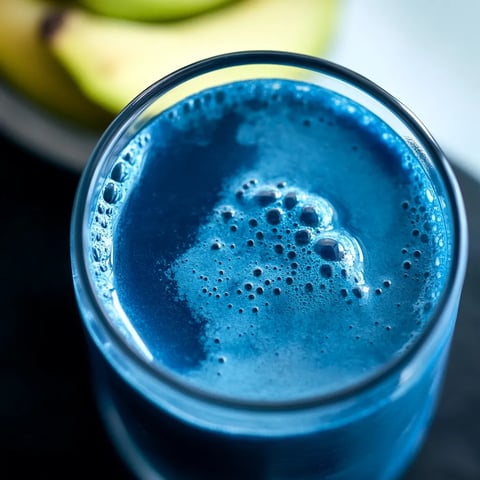 Vibrant blue superfood juice with spirulina powder, packed with nutrients and flavor.