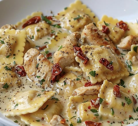 A bowl of pasta with chicken and red peppers.