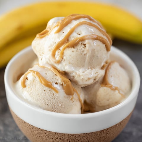 A bowl of ice cream with caramel drizzled on top.