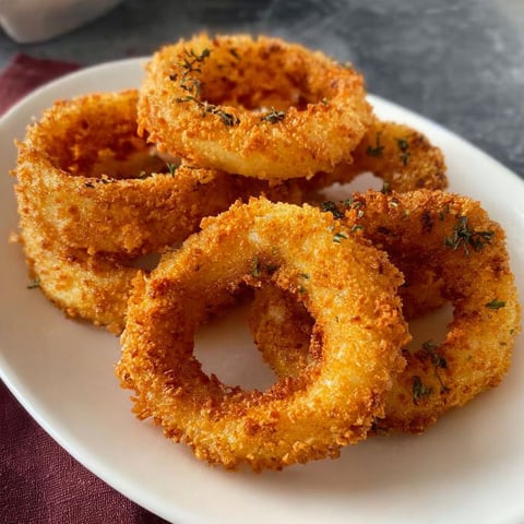 A plate of air fryer onion rings is ready to be eaten.